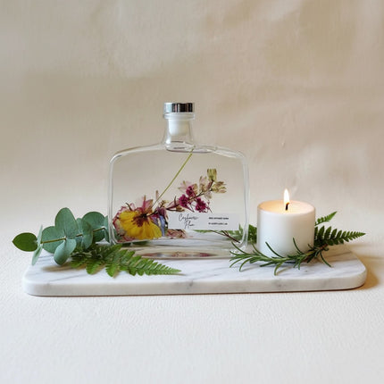 Urbn-cart handmade botanical reed diffuser with dried flowers in a clear glass bottle, silver cap, and a label reading "Cashmere Plum".