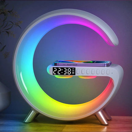 Urbn-cart Mooncave Light G-shaped lamp with RGB light ring, digital clock, wireless charger, and Bluetooth speaker. A smartphone is charging on the pad.